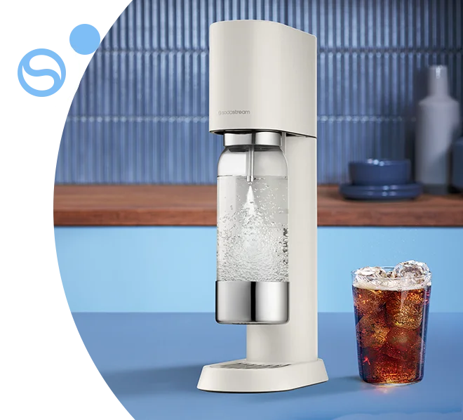 Saturator Sodastream Enso oraz szklanka z napojem na tle niebieskiej kuchni